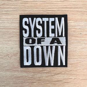 May include: Black embroidered patch with white lettering that reads "SYSTEM OF A DOWN".