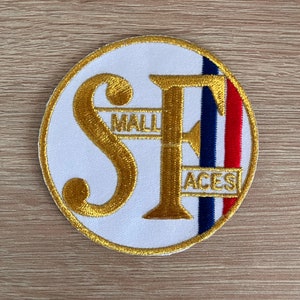 Könnte beinhalten: Ein weißer runder Patch mit goldenen gestickten Buchstaben "SF" mit den Worten "Mall Aces" in kleineren goldenen Buchstaben. Der Patch hat einen roten, weißen und blauen Streifen auf der rechten Seite.