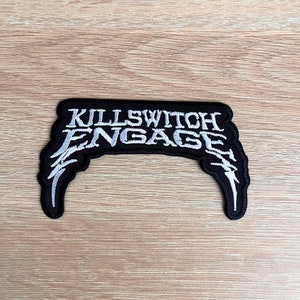Peut inclure: Écusson brodé noir et blanc avec le texte "Killswitch Engage" dans une police blanche stylisée.