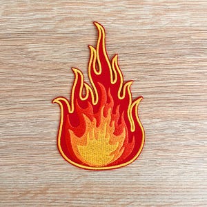 May include: Red and yellow embroidered iron-on patch of a flame design.