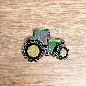 Peut inclure: Patch brodé représentant un tracteur vert et noir avec des roues jaunes.