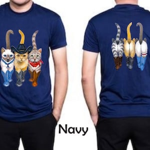May include: A navy blue t-shirt with a graphic of four cats wearing cowboy hats and boots. The cats are walking in a line, with the cat in the front wearing a sheriff's star. The back of the shirt features the same graphic, but the cats are facing away from the viewer.