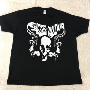 May include: Black t-shirt with a white graphic of a skull with the text "Electric Wizard" above it.