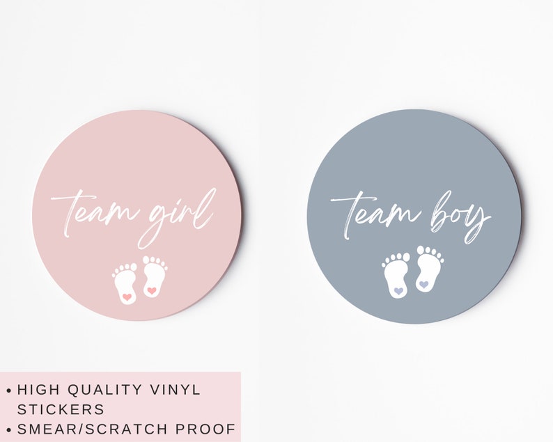 May include: Two round stickers, one pink and one blue, with the text "team girl" and "team boy" in white script. Each sticker features a pair of white baby footprints with a small pink or blue heart.