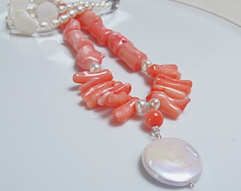 Set di collana in corallo rosa e perla bianca a forma di moneta.
