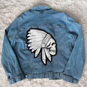 May include: A blue denim jacket with a white and black skull wearing a headdress patch on the back.
