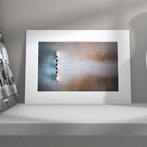 May include: A framed photograph of a bridge viewed from above. The bridge is made of concrete and has a blue and brown color scheme. The bridge is surrounded by water.