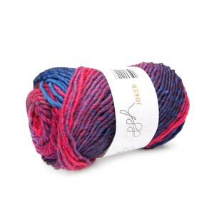 Peut inclure: Pelote de laine Joker aux couleurs bleu, rose et violet. La laine est bien enroulée et porte une étiquette blanche avec le mot "Joker" et un logo. Parfait pour les projets de tricot et de crochet.