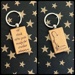 May include: Wooden keyring with a silver ring and a rectangular wooden tag. The tag has the text "I think I'm quite ready for another adventure" engraved on it.