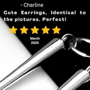 May include: Close-up of shiny, silver earrings with a minimalist design. The image includes text that reads "Cute Earrings, Identical to the pictures." and a five-star rating. The background is black and white.