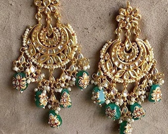 Peut inclure: Une paire de boucles d'oreilles en or avec des motifs complexes et des perles vertes et blanches. Les boucles d'oreilles présentent une forme de croissant de lune avec un motif floral et sont ornées de perles et de pierres précieuses.