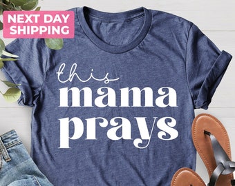 May include: A navy blue t-shirt with the text "this mama prays" in white lettering.