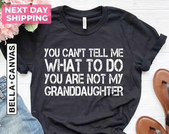 May include: Black t-shirt with white text that reads "You can't tell me what to do you are not my granddaughter".