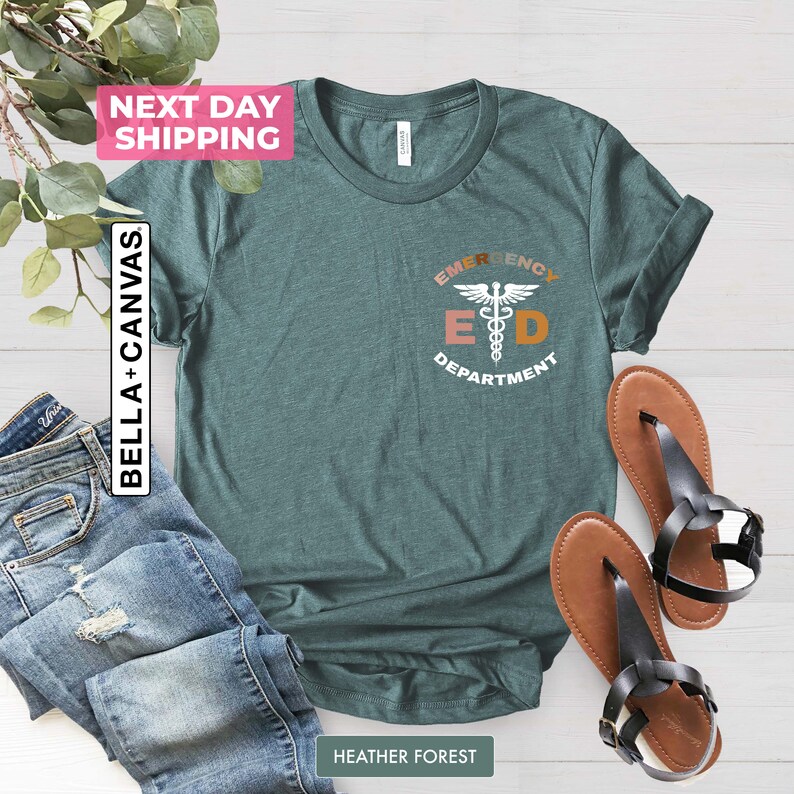May include: A teal green t-shirt with a graphic of a medical symbol and the text "Emergency Department" in a colorful font.