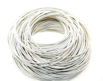 May include: A close-up of a bundle of silver-coloured wire, coiled into a circular shape.