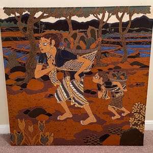 Op de afbeelding: Een artistiek schilderij toont twee figuren die manden dragen, tegen een achtergrond van bomen en een rivier. De figuren zijn gekleed in kleding met patronen, met een warm kleurenpalet van bruin, oranje en blauw. Het kunstwerk roept een gevoel van cultureel erfgoed op.