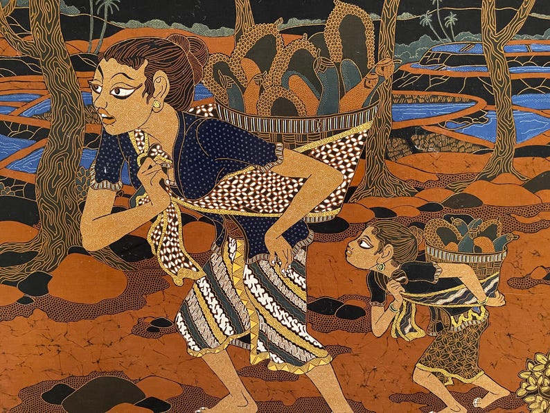 Op de afbeelding: Een Indonesisch batikschilderij toont twee figuren die manden met fruit door een bos dragen. De vrouw vooraan draagt een blauwe top en een patroon sarong. De tweede figuur, een kind, volgt met een kleinere mand. De achtergrond toont bomen, een rivier en een donkere lucht.