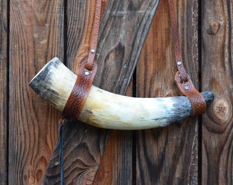 Natuel raw Viking blow horn with brown embossed leather shoulder strap. Length 40cm and 1,2L. VHF 35.