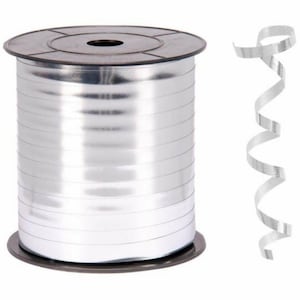 Puede incluir: Un rollo de cinta de curling plateada. La cinta está enrollada alrededor de un carrete de plástico negro. Un trozo de cinta está enrollado en espiral.