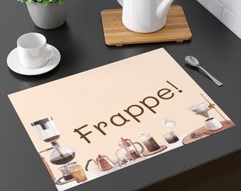 May include: A beige placemat with the word "Frappe!" in brown script. The placemat features watercolor illustrations of coffee brewing equipment, including a siphon, kettle, and French press. A white cup and saucer are on the left.