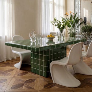 May include: A dining room featuring a green tiled table with white chairs. A large, decorative light fixture hangs above the table. The room has hardwood floors and sheer white curtains.