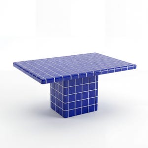 May include: A contemporary coffee table featuring a striking blue tiled top and a cube-shaped base. The tiles are arranged in a grid pattern with white grout. The table measures approximately 122 cm long, 61 cm wide, and 41 cm high.