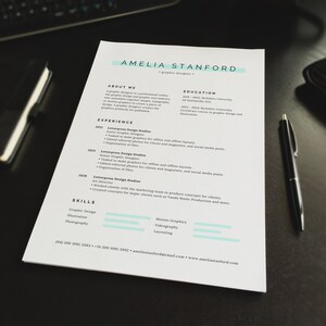 May include: A resume for Amelia Stanford, a graphic designer. The resume lists her experience, education, and skills. The resume is printed on white paper and has a light blue accent colour.