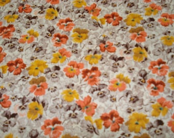 May include: Floral fabric with a repeating pattern of orange, yellow, and brown flowers on a light gray background. The flowers have detailed petals and are evenly spaced across the fabric.