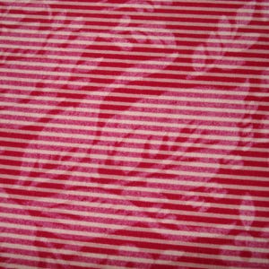 May include: A close-up shot of a fabric featuring a red and white striped design. The stripes run horizontally across the material. Subtle floral patterns are also visible, adding a delicate touch to the overall design.