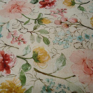 May include: A close-up of a floral design with large pink and red roses, yellow flowers, and small blue blossoms. Green leaves and stems are set against a cream background, creating a watercolour effect. Suitable for fabric or wallpaper.