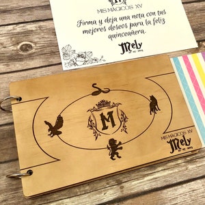 May include: A wooden guest book with a laser-etched design, featuring a crest with the letter "M" and decorative elements. Includes a card with text in Spanish and a colorful patterned paper.