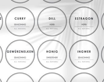 May include: Nine round white labels with black borders and text. The labels are for different herbs and spices, including curry, dill, estragon, ginger, and cardamom. Each label says "All Natural" and indicates whether the item is a herb or seasoning.