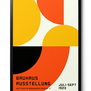 May include: A Bauhaus exhibition poster with a geometric design featuring overlapping circles in yellow, orange, and black. The text reads "Bauhaus Ausstellung" and "Juli-Sept 1923" with the address "Sotterlin Badenerstrasse 11".