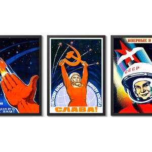 Op de afbeelding: Set van drie ingelijste vintage Sovjet-ruimtepropaganda-posters. De posters tonen levendige kleuren en beelden van raketten, kosmonauten en het Sovjet-ruimteprogramma. Elke poster heeft een zwart frame en bevat Russische tekst.
