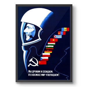 Może przedstawiać: Winietkowy plakat propagandowy Związku Radzieckiego przedstawiający niebiesko-białą ilustrację kosmonauty w hełmie. Plakat zawiera tekst "Мы дружим и созидаем. И в космосе мир утверждаем!" kt&oacute;ry tłumaczy się jako "Jesteśmy przyjaci&oacute;łmi i tworzymy. I w kosmosie potwierdzamy pok&oacute;j!" Plakat zawiera r&oacute;wnież szereg flag z r&oacute;żnych kraj&oacute;w, w tym Związek Radziecki, Kubę, Wietnam i inne.