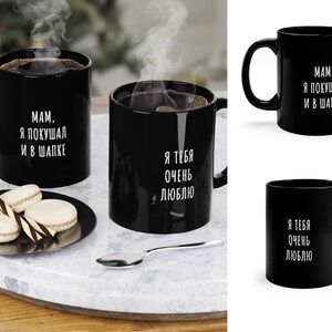 May include: Two black coffee mugs with white text. One mug says "MAM, YA POKUSHAL I V SHAPKE" and the other mug says "YA TEBYA OCHEN LYUBLYU".
