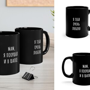 May include: Two black coffee mugs with white text. One mug says "MAM, I ATE IN A HAT" and the other says "I LOVE YOU VERY MUCH".