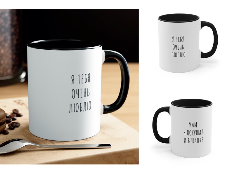 May include: Two white ceramic mugs with black rims. The mug on the left has the text "Я ТЕБЯ ОЧЕНЬ ЛЮБЛЮ" printed in black. The mug on the right has the text "MAM. Я ПОКУШАЛ И В ШАПКЕ" printed in black.