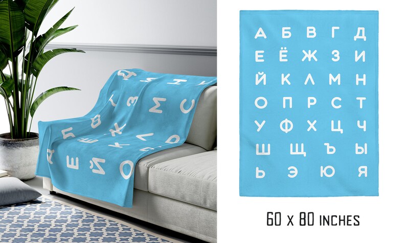 May include: A light blue fleece blanket with a white Cyrillic alphabet pattern. The blanket is 60 inches by 80 inches.