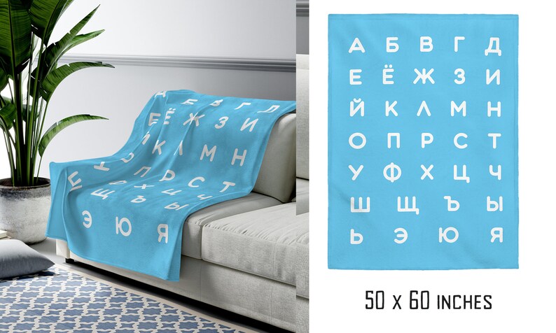May include: A light blue fleece blanket with the Cyrillic alphabet printed in white. The blanket is 50 by 60 inches.