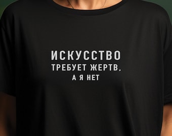 以下が含まれることがあります： 白い文字で「Искусство требует жертв, а я нет」と書かれた黒いTシャツ。