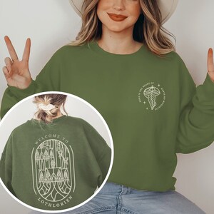 May include: Green sweatshirt with a white graphic on the front that says "Where is the heart of Elves no longer found?" and a white graphic on the back that says "Welcome to Lothlorien".