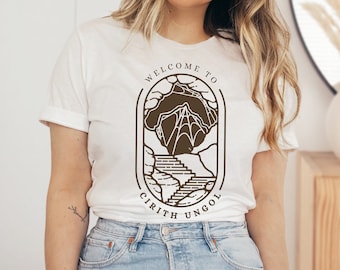 May include: White t-shirt with a brown graphic design of a mountain range with the text "Welcome to Cirith Ungol".