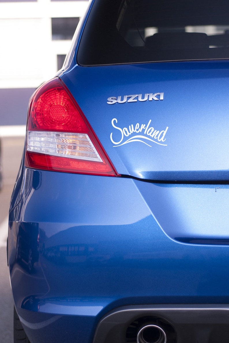 May include: A blue Suzuki car with a white "Sauerland" sticker on the back.