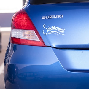May include: A blue Suzuki car with a white "Schwarzwald" sticker on the back.