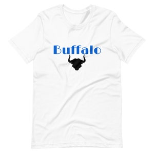 Può includere: Maglietta bianca con la parola "Buffalo" in blu e una silhouette nera di testa di bufalo.