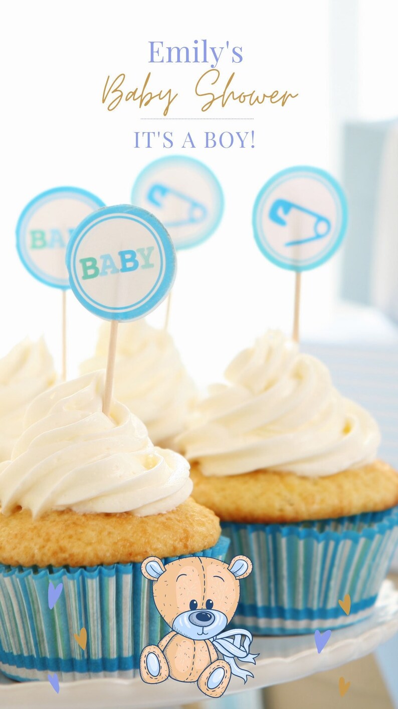 May include: Blue and white cupcakes with white frosting decorated with blue and white baby shower toppers. The toppers say "Baby" and "It's a Boy!" A teddy bear is in the foreground.