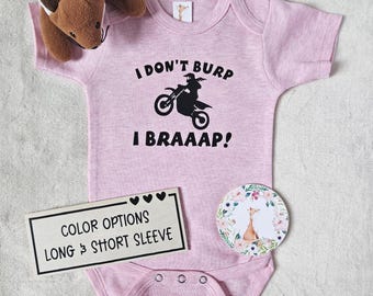 Könnte beinhalten: Hellrosa Baby-Body mit dem Text "I DON'T BURP I BRAAAP!" und einer schwarzen Motorradgrafik. Ein Plüschfuchs-Spielzeug und ein Schild mit der Aufschrift "COLOR OPTIONS LONG & SHORT SLEEVE" sind ebenfalls abgebildet.