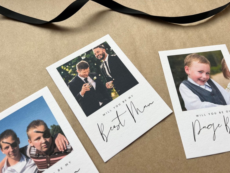 May include: White cards with photographs and black script text. One card reads "Will you be my Best Man" with a photo of two men in suits. Another card reads "Will you be our Page Boy" with a photo of a young boy.
