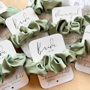 Peut inclure: Ensemble de chouchous en satin vert avec des cartes blanches qui disent "Bride Tribe" et "To have and to hold your hair back".